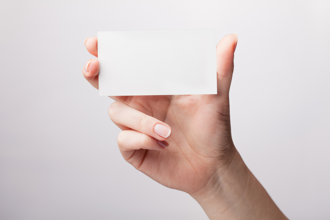 Businesswoman’s hand holding blank paper business card, closeup
